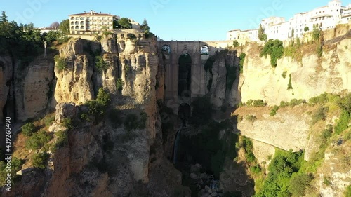 AERIAL - Epic view of old bridge, Ronda, Malaga, Spain, wide shot rising forward photo