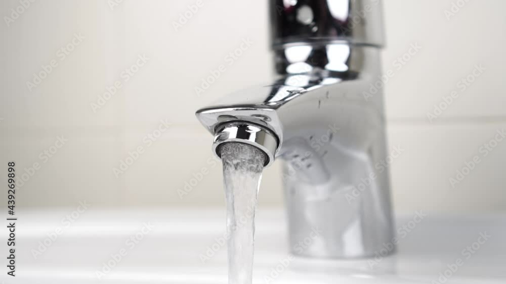 Slow motion of the flow of tap water from a bathroom faucet. Close up Slow motion of the flow of tap water from a bathroom faucet. Close up