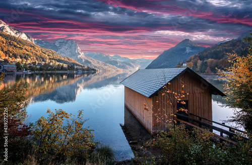 Wonderful Autumn Morning over the alpine lake Grundlsee with Colorful sky. Amazing nature landscape with mountains, colorful sky, alpine lake and fishing hut on foreground, Grundlsee, Styria, Austria.