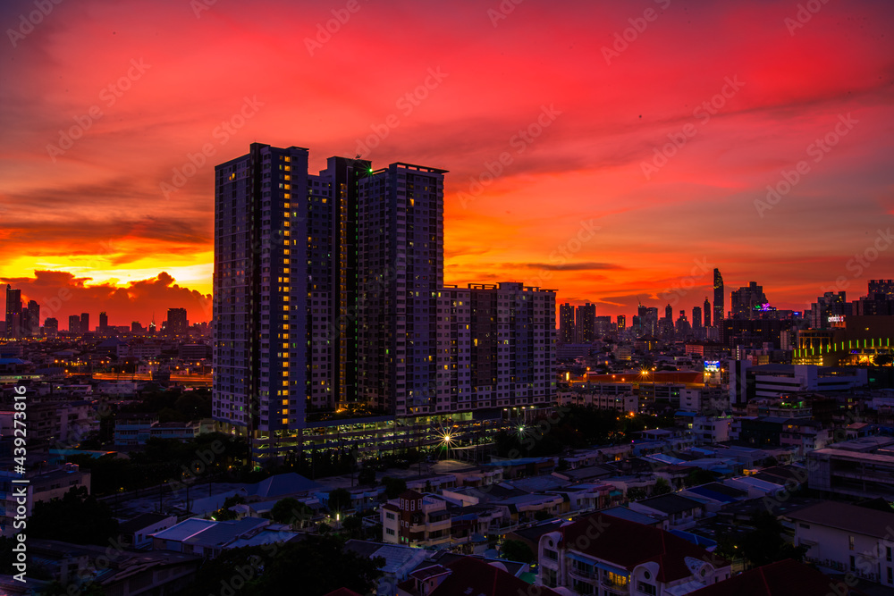 Fototapeta premium The high angle background of the city view with the secret light of the evening, blurring of night lights, showing the distribution of condominiums, dense homes in the capital community