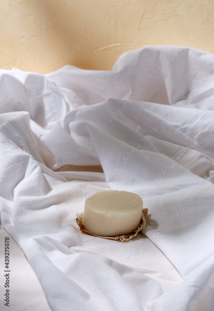 natural cosmetics, hygiene and beauty concept - bar of craft soap on white sheet natural cosmetics, hygiene and beauty concept - bar of craft soap on white sheet
