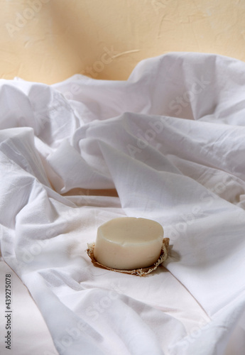 natural cosmetics, hygiene and beauty concept - bar of craft soap on white sheet
