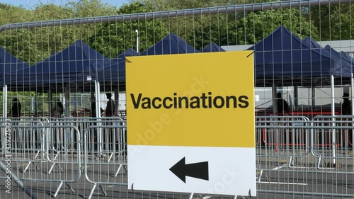 Vaccinations sign directing people at a COVID-19 vaccine centre. People in the UK getting coronavirus vaccine jab. photo