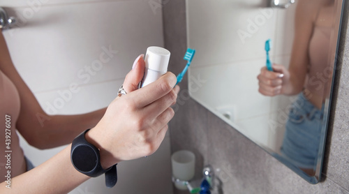 Young woman holding toothbrush before brushing teeth.