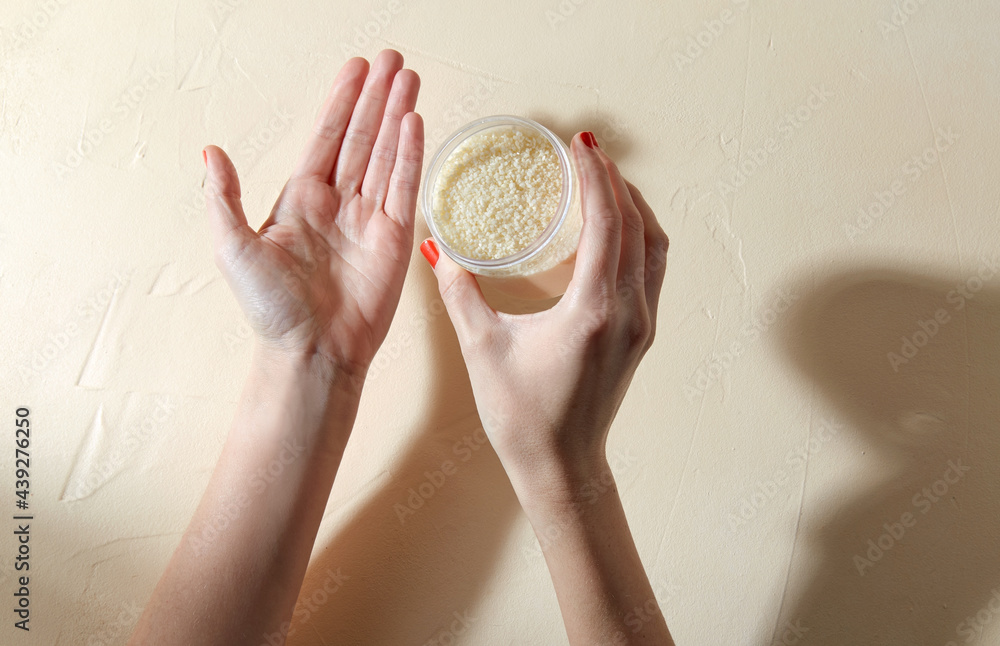 Fototapeta premium beauty product, cosmetics and people concept - hands with bath salt in jar