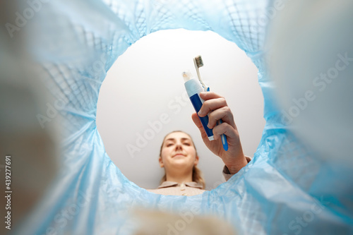 Fotografie recycling, waste sorting and sustainability concept - woman throwing toothbrush