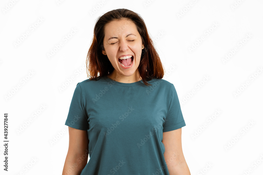 Portrait of young woman screams. White background. The concept of negative human emotions Portrait of young woman screams. White background. The concept of negative human emotions