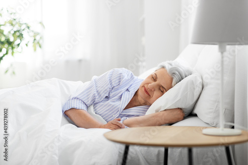Obraz na plátně old age and people concept - senior woman sleeping in bed at home bedroom
