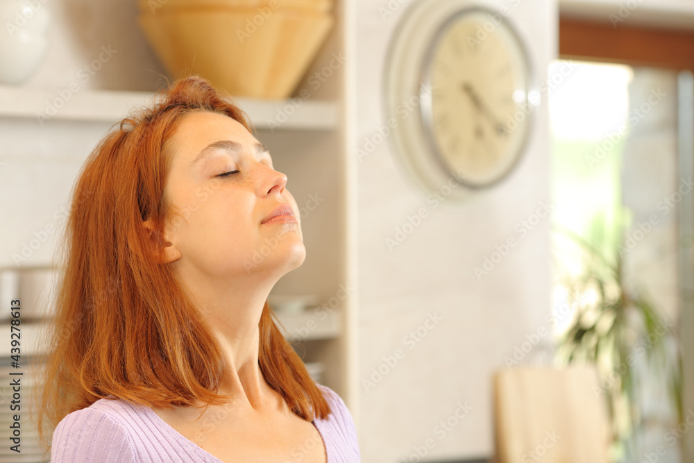 Woman breathing fresh air in the kitchen Woman breathing fresh air in the kitchen