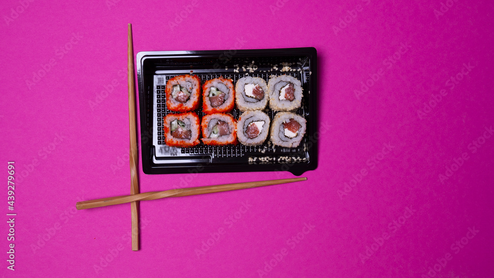 a small portion of rolls with fish on a pink background a small portion of rolls with fish on a pink background
