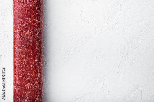 Salami smoked sausage, on white stone background, top view flat lay, with copy space for text