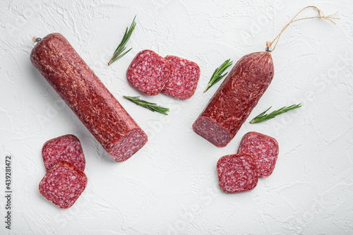 Salami with ingredients, on white stone table background, top view flat lay