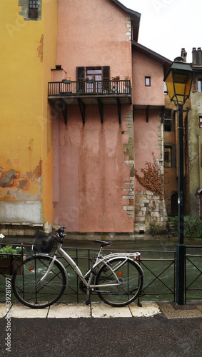 Fototapeta Naklejka Na Ścianę i Meble -  a classic street lantern next to a bicycle in front of the river against the backdrop of a traditional building, Annesy, France