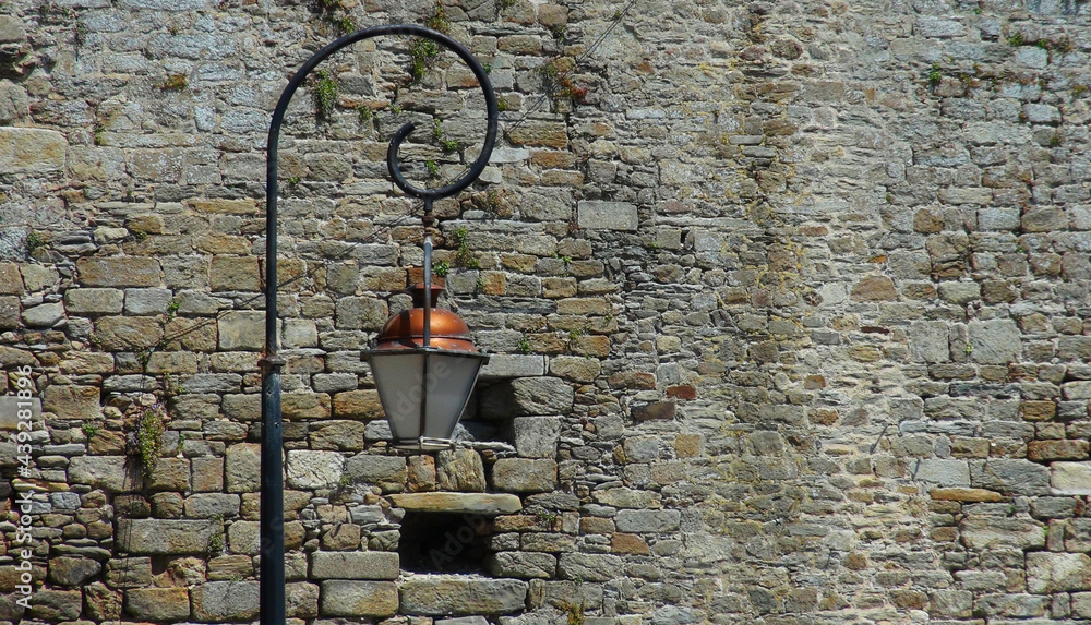 a traditional street lantern, street light in front of a stone wall, St.Malo, France a traditional street lantern, street light in front of a stone wall, St.Malo, France