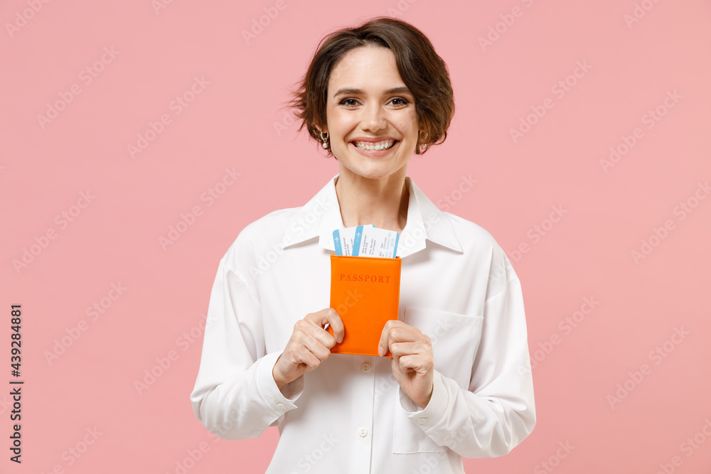 Traveler fun tourist employee business woman in formal white shirt hold passport tickets isolated on pastel pink background. Passenger travel abroad on weekends getaway. Air flight journey concept. Traveler fun tourist employee business woman in formal white shirt hold passport tickets isolated on pastel pink background. Passenger travel abroad on weekends getaway. Air flight journey concept.