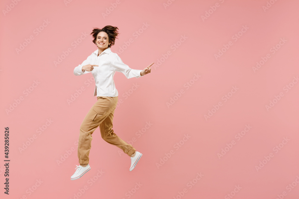 Full length young successful employee business woman corporate lawyer in classic formal white shirt work in office jump high point index finger aside on workspace isolated on pastel pink background
