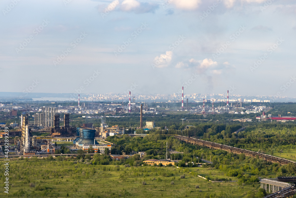 Oil refinery in the summer against the backdrop of nature.