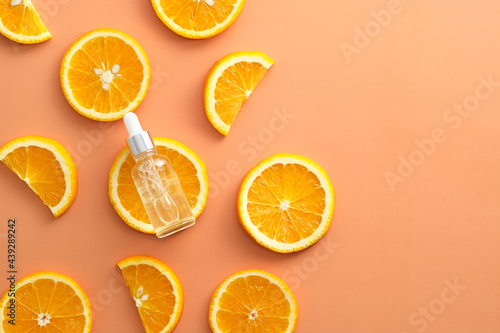 Vitamin c serum extract with sliced orange top view. Natural skin care cosmetics.