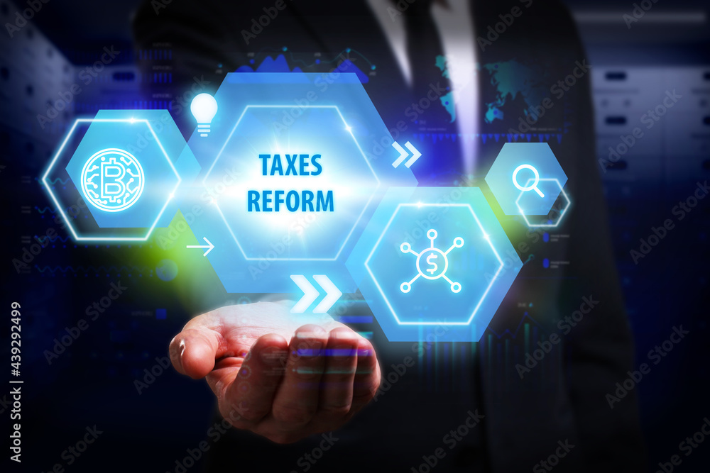 Business, Technology, Internet and network concept. Young businessman working on a virtual screen of the future and sees the inscription: Taxes reform Business, Technology, Internet and network concept. Young businessman working on a virtual screen of the future and sees the inscription: Taxes reform
