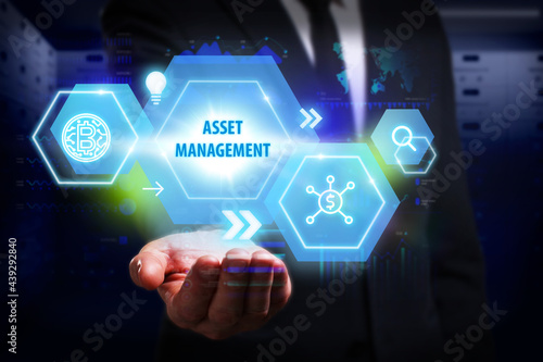 Business, Technology, Internet and network concept. Young businessman working on a virtual screen of the future and sees the inscription: Asset management