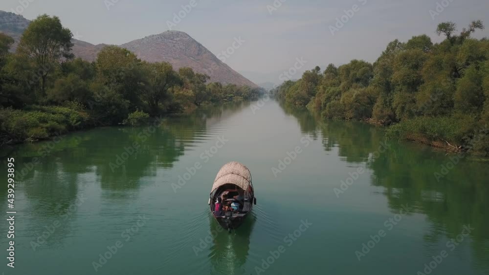 Aerial view of a Tourist Boat sailing on Skadar lake with lush vegetation, Montenegro, Europe Aerial view of a Tourist Boat sailing on Skadar lake with lush vegetation, Montenegro, Europe