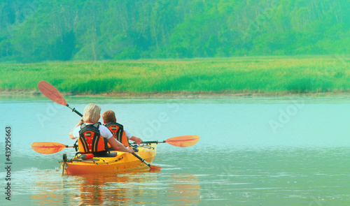 Kayaking and canoeing with family. The woman with a child on the lake and ride on kayak
