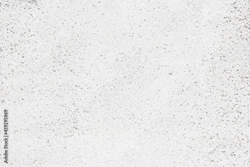 Whitewashed exposed aggregate concrete texture. White rough cement with pebble surface
