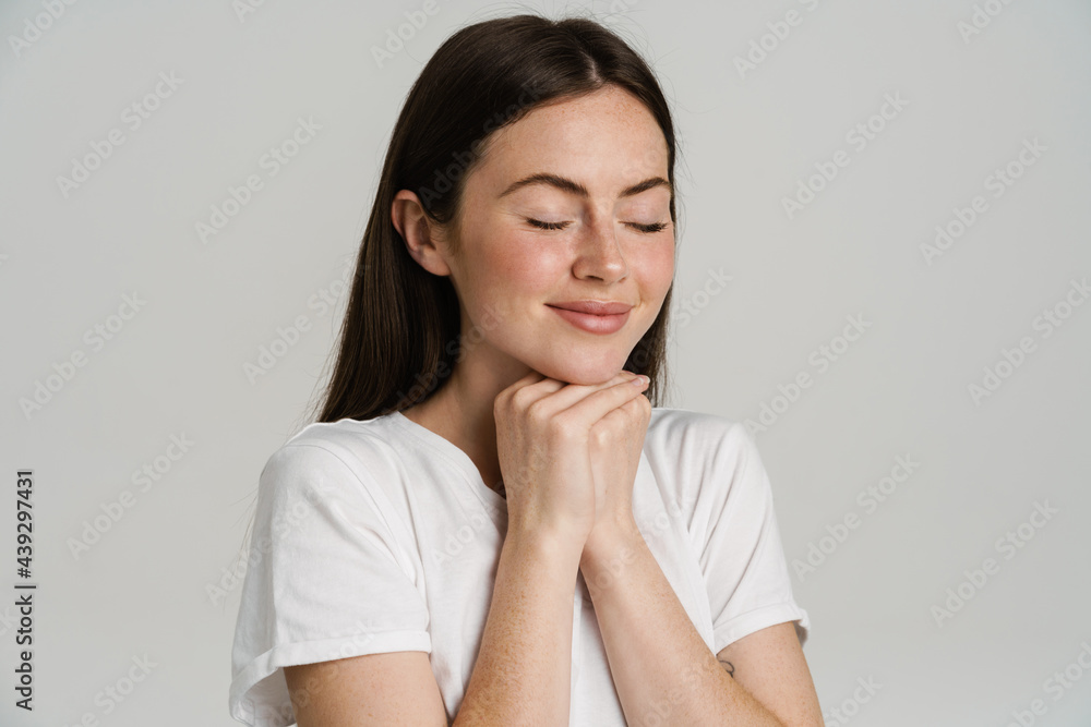 Young brunette woman in t-shirt smiling with her eyes closed Young brunette woman in t-shirt smiling with her eyes closed
