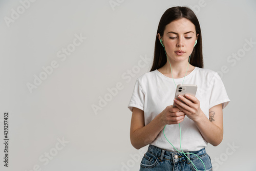 Young brunette woman listening music with earphones and cellphone