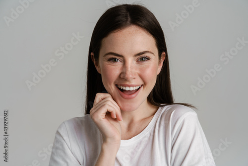 Young brunette woman in t-shirt smiling and looking at camera