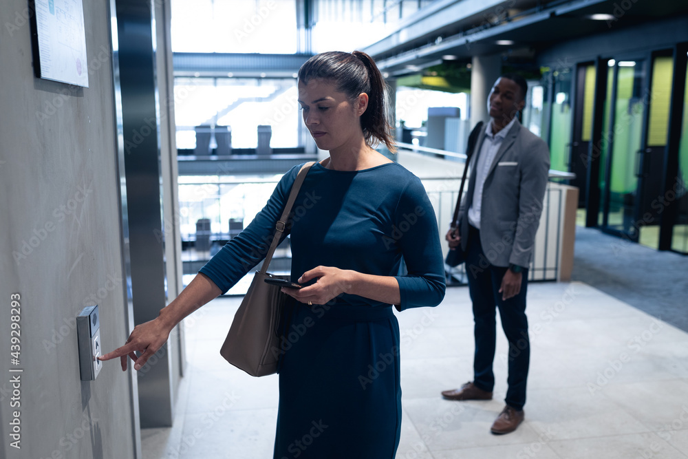 © Wavebreak Media - Caucasian businesswoman holding smartphone pressing the lift button at modern office © Wavebreak Media - Caucasian businesswoman holding smartphone pressing the lift button at modern office
