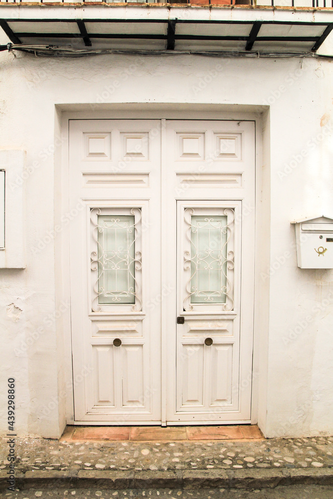 Whitewashed facade with beautiful white wooden door