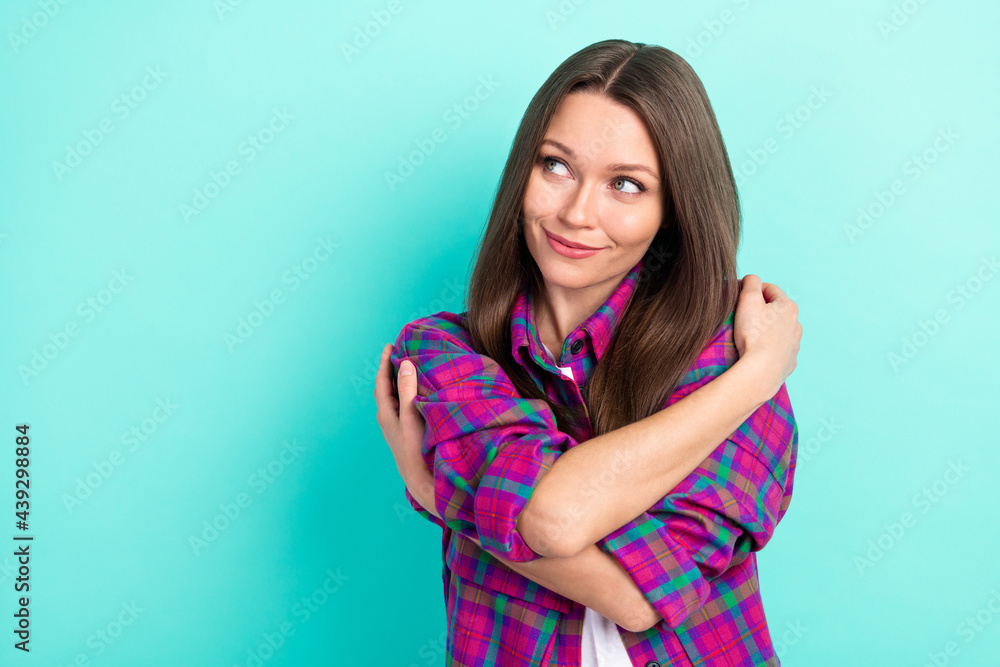 Portrait of attractive cheerful girl hugging herself thinking copy space isolated over bright teal green color background Portrait of attractive cheerful girl hugging herself thinking copy space isolated over bright teal green color background