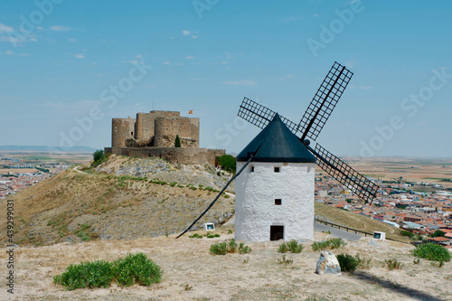 Whitewashed windmill near the castle in Consuegra town, Toledo province, Castilla-La Mancha, Spain. Popular weekend destination for people from Madrid. Also known as route of Cervantes