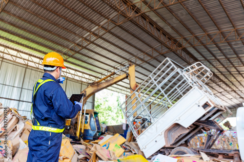 Engineer pointing forward. Engineer driving a loader in the recycling plant.