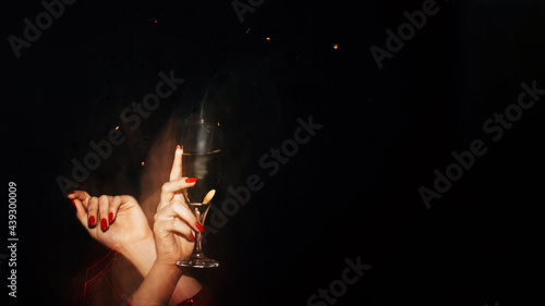 Festive drink. Party celebration. Birthday holiday. Toast cheer. Unrecognizable woman holding glass of champagne isolated black defocused long exposure copy space.