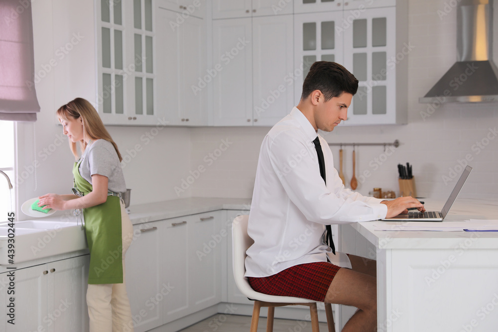 Man working on laptop in kitchen. Stay at home concept Man working on laptop in kitchen. Stay at home concept