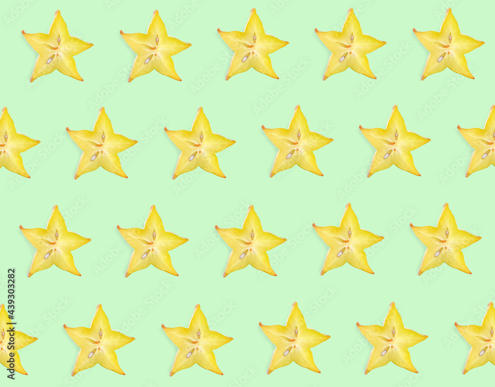 Obraz premium Slices of carambola on light green background, flat lay