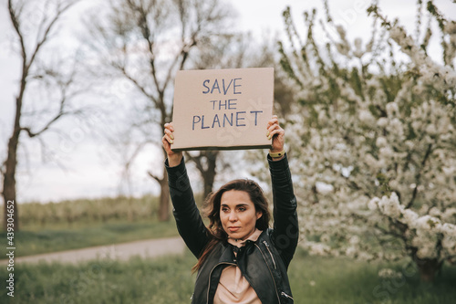 Portrait of woman with a banner with the slogan Save the Planet. Fight climate change, girl with protest. Environmental activist woman with poster. Ecology sign of protest for green future of planet.
