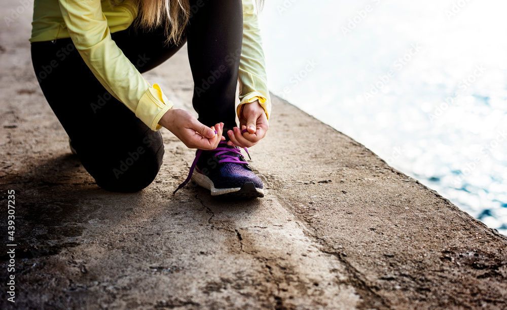 Jogger on a break tying her shoelaces