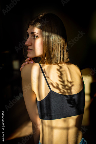 Beauty portrait of a back beautiful young girl with a shadow pattern on the face and body in the form of stripes. fashion  beauty. Female clavicle of green leaves. Close up.