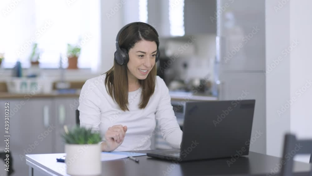 Woman with headphones making video call from home Woman with headphones making video call from home