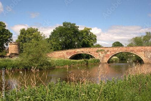 stone bridge and tower on river Tyne Haddington in summer