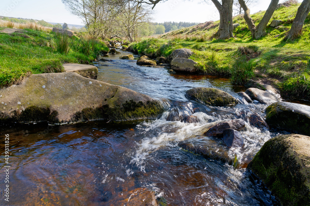 Fototapeta premium Burbage brook becomes a blur flowing over gritstone rocks