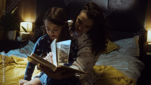 Young mother reading a book in the bed