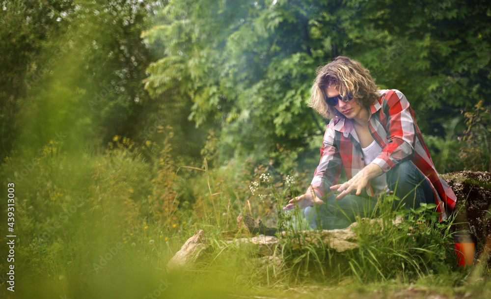 Man warms his hands by the bonfire in the forest. Man warms his hands by the bonfire in the forest.