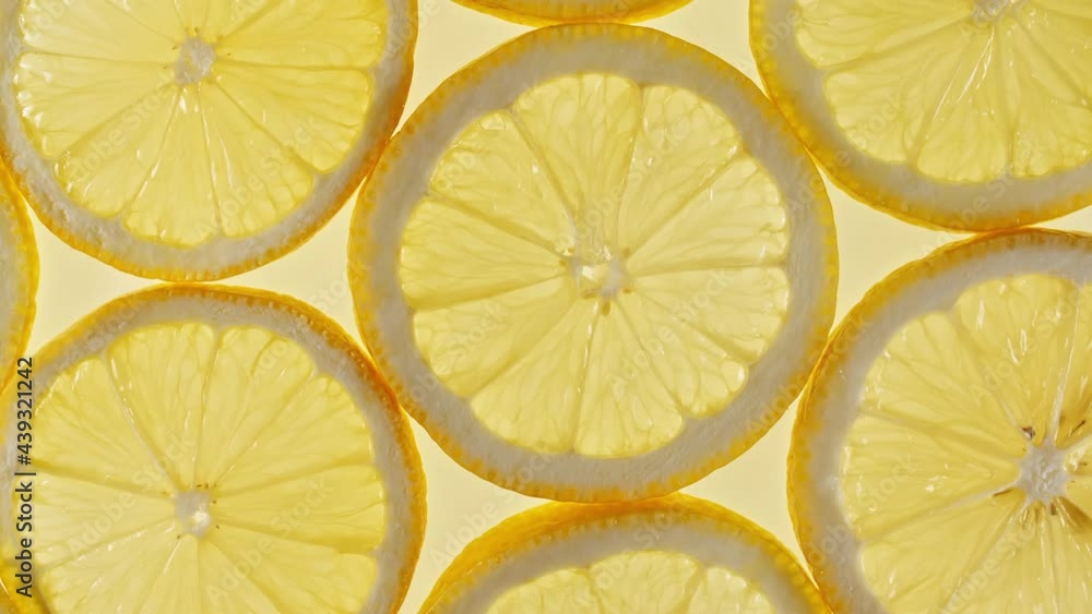 Slow Motion of Fresh Lemons Slices on Yellow Background. Lemons Fruit Pattern. Healthy Food Background. Macro Shot. High quality 4k footage Slow Motion of Fresh Lemons Slices on Yellow Background. Lemons Fruit Pattern. Healthy Food Background. Macro Shot. High quality 4k footage