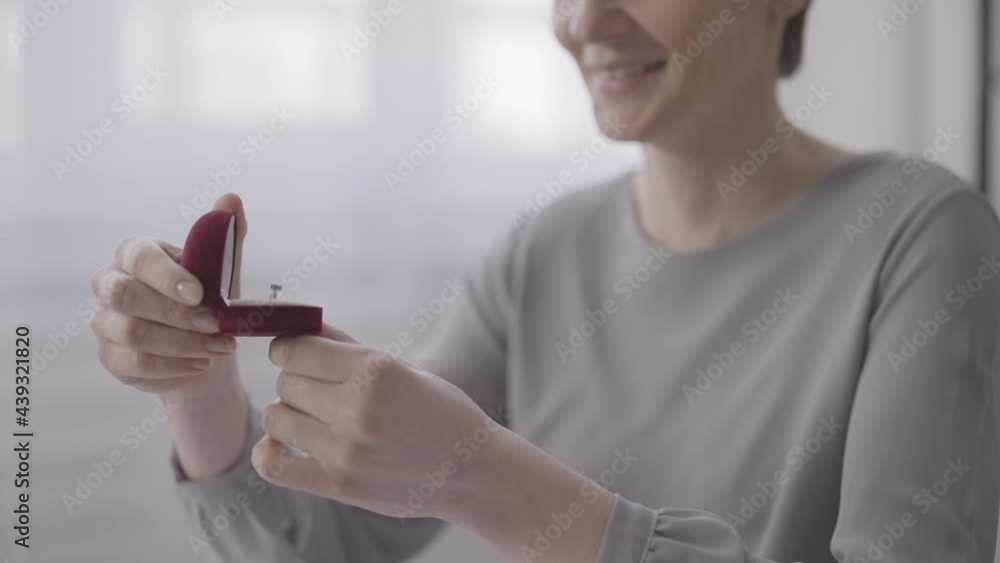 Nervous woman looking at ring in jewelry box, deciding to make marriage proposal Nervous woman looking at ring in jewelry box, deciding to make marriage proposal
