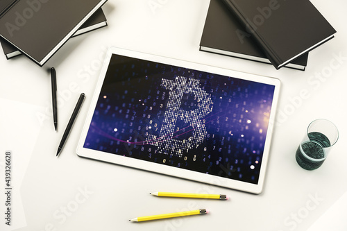 Top view of modern digital tablet screen with creative Bitcoin symbol hologram. Mining and blockchain concept. 3D Rendering