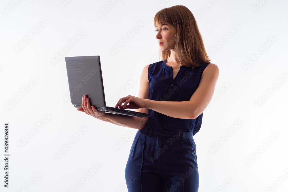 Woman with laptop on a white background. She is dressed in stylish casual clothes. Businesswoman with computer in her hands. Concept she works in a computer. Business program in her laptop. Woman with laptop on a white background. She is dressed in stylish casual clothes. Businesswoman with computer in her hands. Concept she works in a computer. Business program in her laptop.